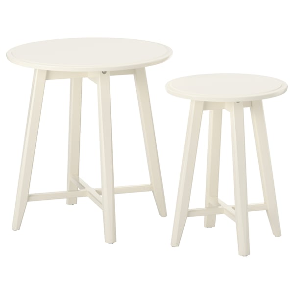 Dva bílé, kulaté hnízdové stolky s elegantními, zužujícími se nohami, navržené ikea.