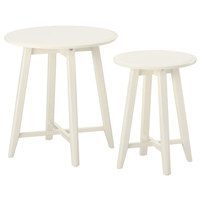 Dva bílé, kulaté hnízdové stolky s elegantními, zužujícími se nohami, navržené ikea.