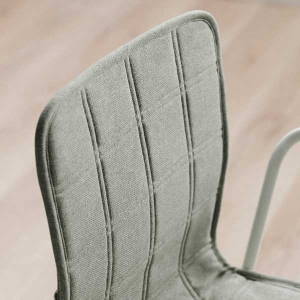 Detailní záběr na stylové, čalouněné opěradlo židle, které ukazuje svůj elegantní design a vysoce kvalitní látku.