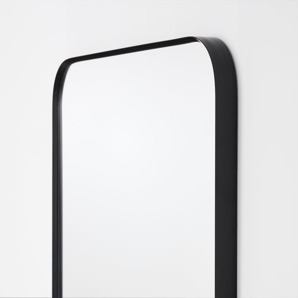 Elegantní zrcadlo LINDBYN s elegantním černým rámem, zaoblenými rohy, které odráží minimalistický styl.