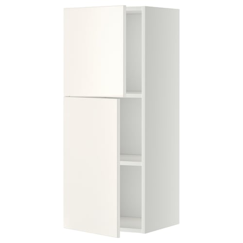 Bílá kuchyňská nástěnná skříňka METOD s jedněmi dvířky otevřenými, odhalující uvnitř nastavitelnou polici. Má elegantní, moderní design.
