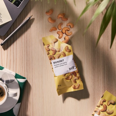 Taška kešu oříšků IKEA MUNSBIT na stole s kávou a zápisníkem