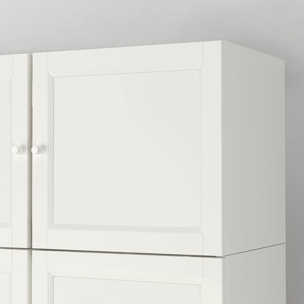 Bílá skříňka s elegantními dveřmi, ukazující kvalitní zpracování, čisté linie a minimalistický design.