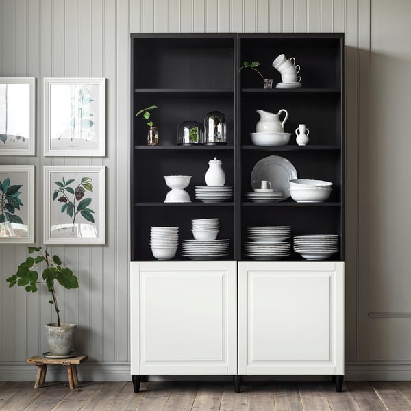 Černobílý úložný díl SMEVIKEN s nádobím, vázami a rostlinami. Moderní, čistý design.