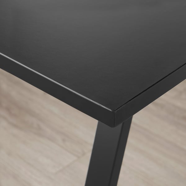 Detailní záběr na elegantní černou stolní desku s hladkými hranami, která se vyznačuje vysoce kvalitním zpracováním a robustní konstrukcí.