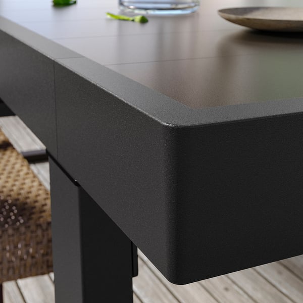 Moderní venkovní stůl VÄRMANSÖ v černé barvě, vyrobený z hliníku, obdélníkového tvaru, elegantní design.