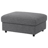 Šedá podnožka VIMLE s odnímatelným potahem pro snadné praní. Její hranatý tvar a černé nohy nabízí moderní design.