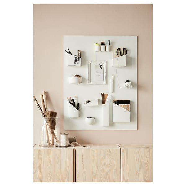Home office with light wood storage, white organiser, office supplies, and a vase of pencils.
