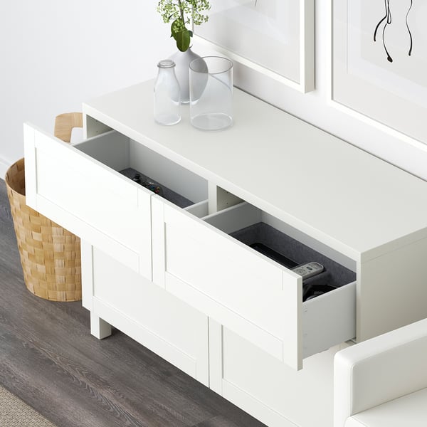 BESTÅ sideboard with remotes, plant, and picture