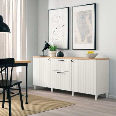 White BESTÅ sideboard with wooden top, 2 doors, 2 drawers, shelves. Artwork above, citrus bowl, plant, lamp.