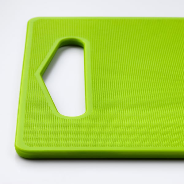 Bright green textured cutting board with large handle cutout.