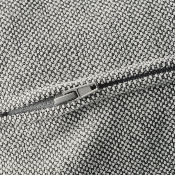 Close-up of KIVIK sofa zip, showcasing durable, textured fabric in black and white dots.