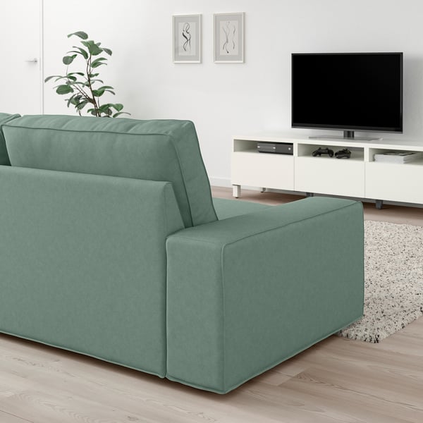 KIVIK sofa in green fabric, large, low armrests, clean lines, spacious for relaxation. Fits well in modern living spaces.