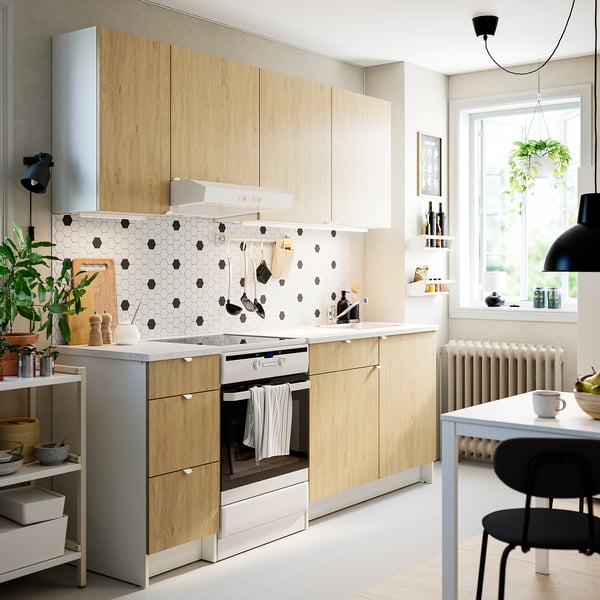 Modern kitchen: light wood, marble, black accents, airy.