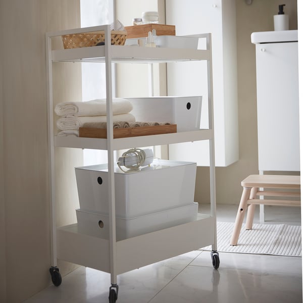 White KUGGIS storage rack with boxes, a basket, and towels.