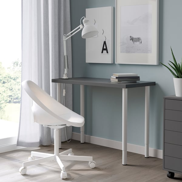 Modern home office: grey LINNMON desk, white lamp, blue wall, art.