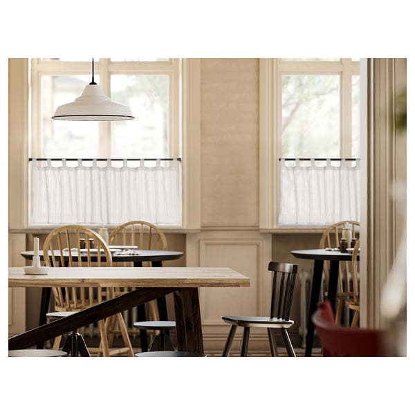 Cosy dining area with wooden furniture, large windows, MATILDA curtains, and a pendant lamp.