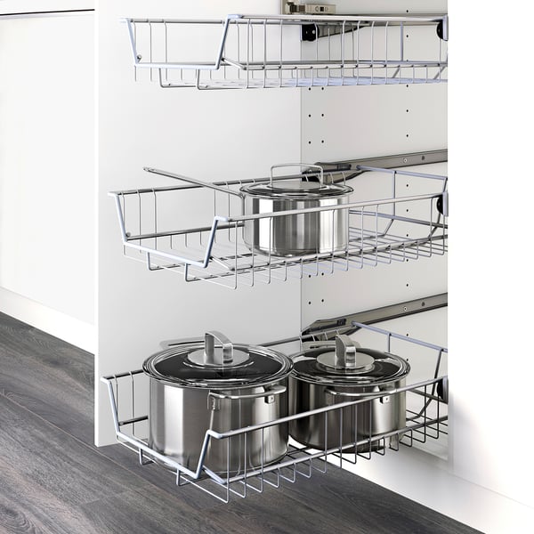 Metal pots and pans organised on three pull-out storage racks inside a white kitchen cabinet.