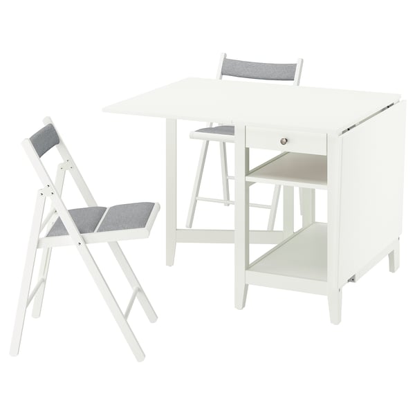 Displays a compact white NÄSINGE drop-leaf table with a fabric folding chair. The table storage shelves and both pieces are designed for small spaces.