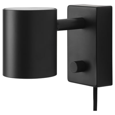 A black NYMÅNE wall lamp with a cylindrical shade and adjustable arm, mounted on a rectangular base.