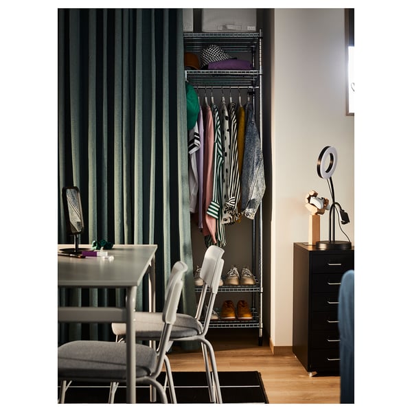 Bedroom with open closet, green curtains, modern table, and black storage cabinet.