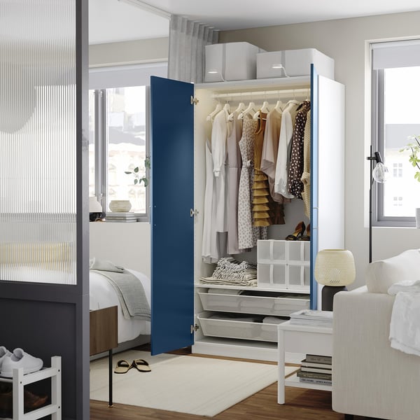 Modern bedroom with blue PAX wardrobe, organised and efficient.