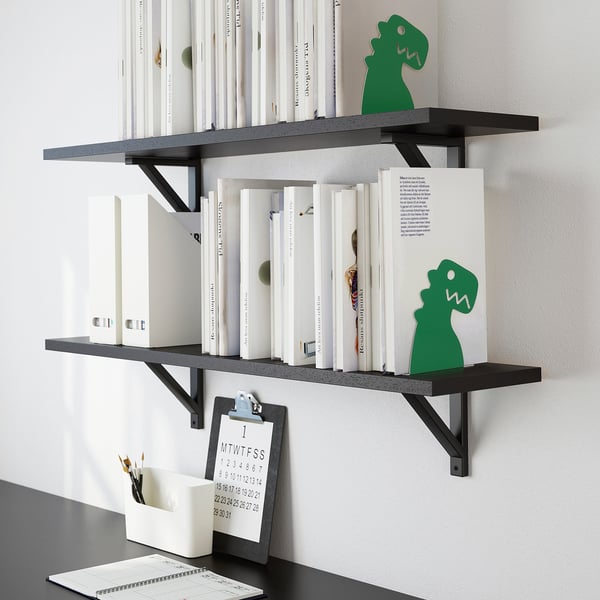 Bookshelves with dinosaur-shaped bookends holding multiple books. Includes a clipboard with calendar and pencils.