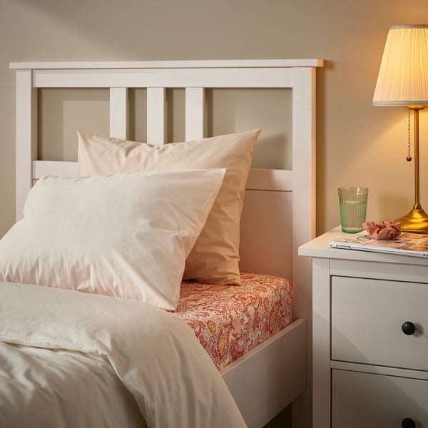 Bed with white RODGERSIA paisley sheet set. Quartz colour, soft fabric, fitted design. Bedside table with lamp beside.