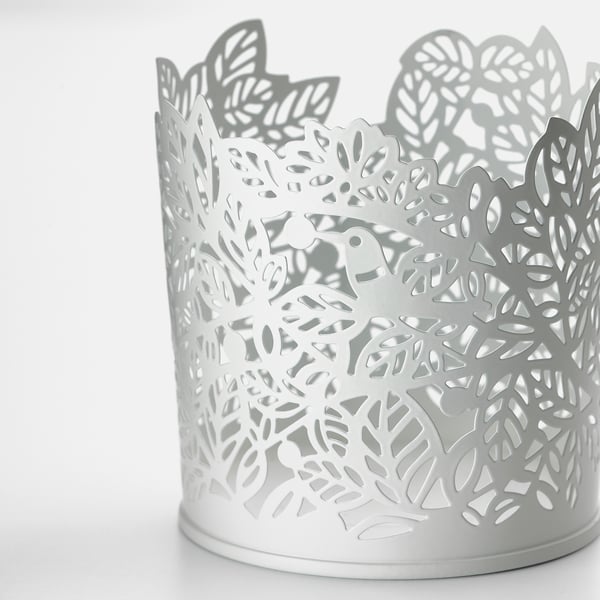 Intricate white metal candle holder with floral design. Elegant, robust, and decorative.