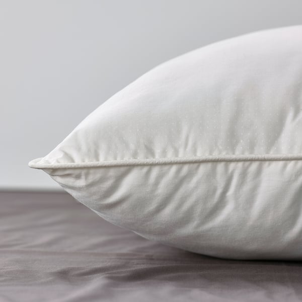 Close-up of a high-quality, white bed pillow on a grey bedsheet.