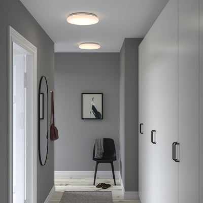 Modern entryway with gray walls, STOFTMOLN lamp, white wardrobe, black chair, and mirror.