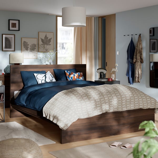 Modern bedroom with STORKLINTA wood bed, blue/beige textiles, minimalist decor, cosy and spacious.