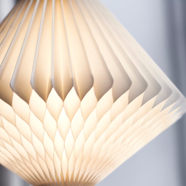 Intricate paper pendant lamp, warm glowing light, crafty design.