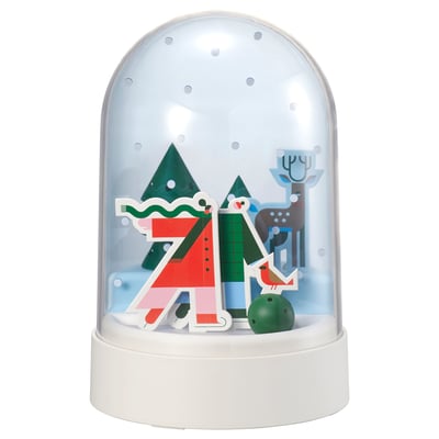 STRÅLA snow globe lamp: white base, clear globe, christmas scene with red, green trees, reindeer, and snowman, lit warmly inside.