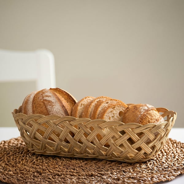 Rustic handwoven STYLTSNÄPPA basket with bread on table.