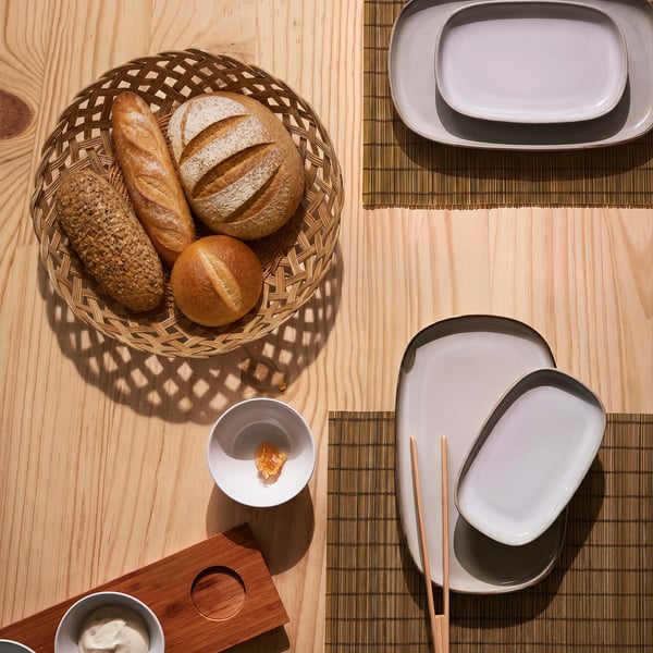 Rattan bread basket with bread on wooden table.