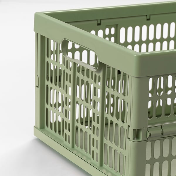 Green plastic storage bin with handles, perforated design, sturdy and stackable for efficient storage.