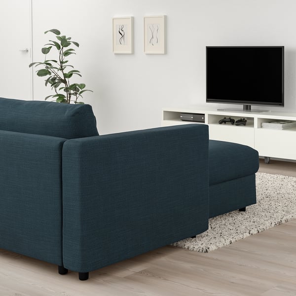 Modern living room with teal l-sofa, tv stand, plant, art, rug.