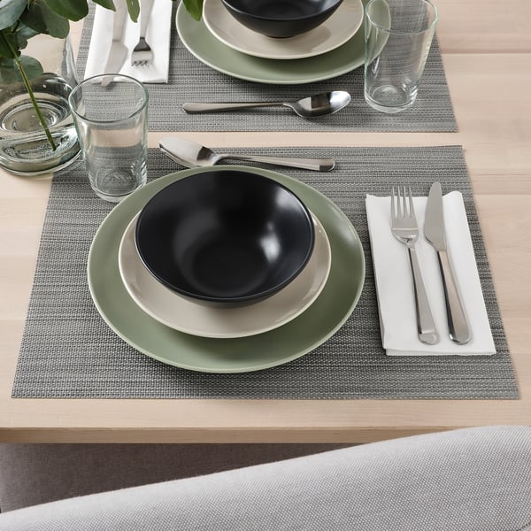 Tischgarnitur mit FÄRGKLAR Schüsseln, Tellern, Besteck und Gläsern auf Tischsets, bereit zum Essen.