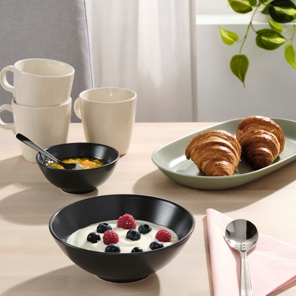 Frühstückstisch mit FÄRGKLAR Schalen, Tassen, Croissants, Joghurt, Beeren, Müsli, Serviette und Löffel.