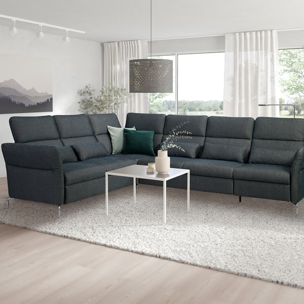 Modernes Wohnzimmer mit dunkelgrauem L-förmigem FAMMARP-Sofa, grünen Kissen, weißem Couchtisch, großen Fenstern und stilvoller Hängelampe.