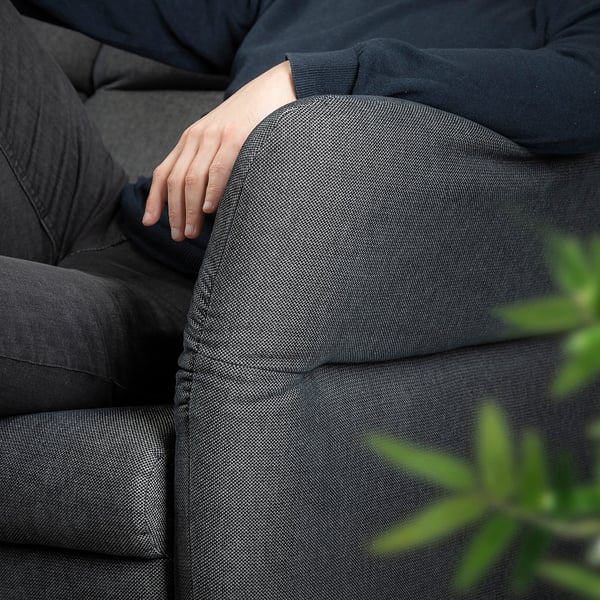 Person ruht auf schwarzem FAMMARP-Sofa, Arm auf Kissen.