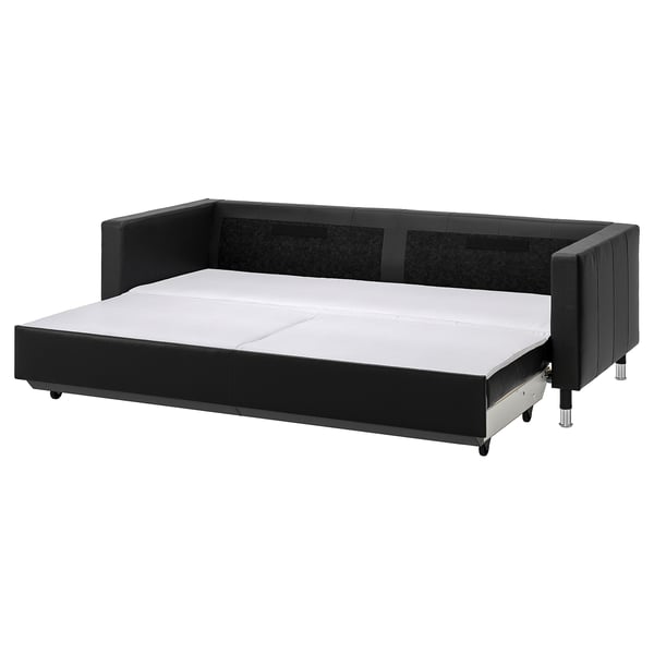 Schwarzes Lederschlafsofa mit Stauraum, verchromten Beinen, Plüschkissen.