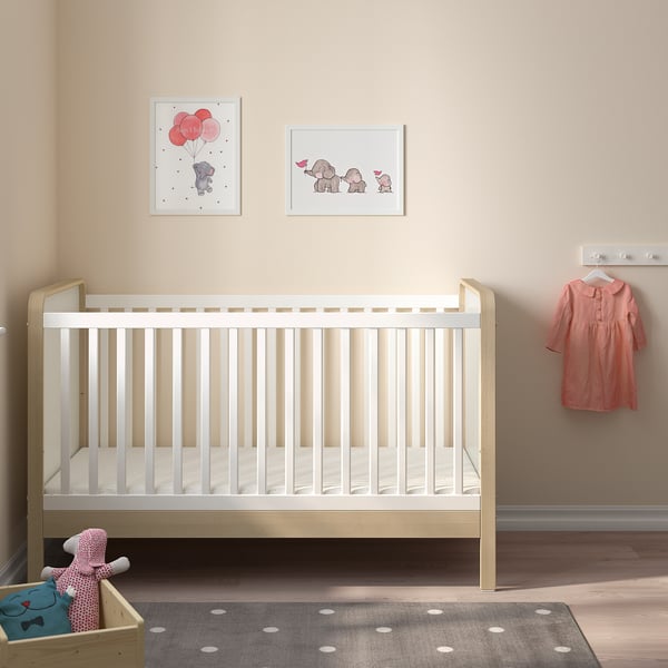 Nursery with ÄLSKVÄRD crib, prints, dress, rug, toy box.