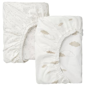 Two white baby bed sheets, one with dots, one with clouds, made of 100% cotton.