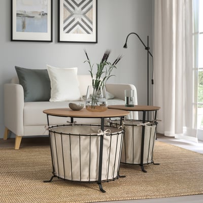 Modern living room with ÄNGESBYN storage table. White fabric, wooden top, black metal base. Small, round, fits neatly near a sofa.
