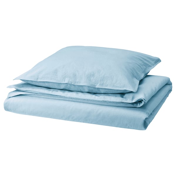 A stack of light blue neatly arranged bed linens, including a duvet cover and two pillowcases, made from soft pre-washed cotton.