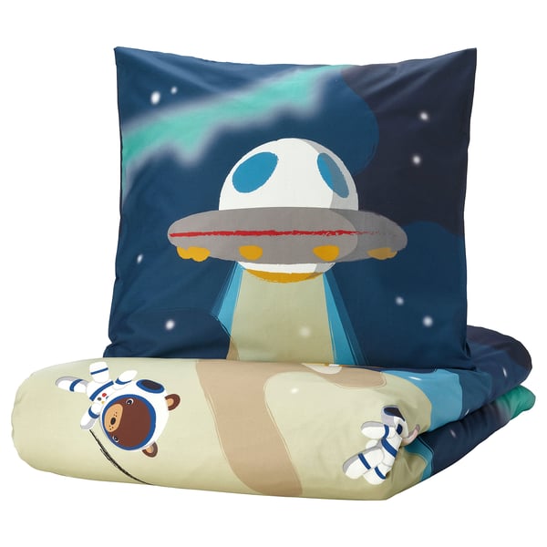 Space-themed bedding set: blue, green, and beige pillow & blanket with alien and astronaut designs.