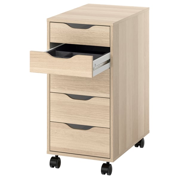 An ALEX light oak wooden drawer unit with black wheels, featuring three drawers. One drawer is open, revealing a black interior and a metal divider.