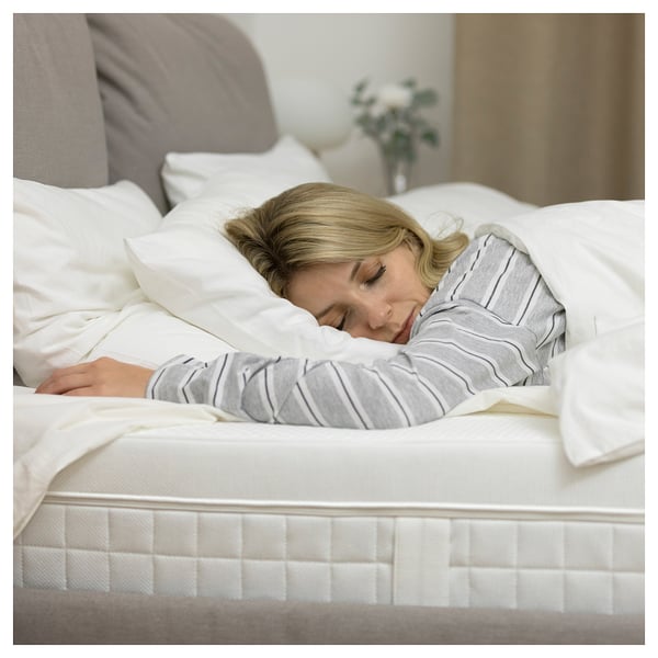 Person sleeping on white ÅVABERG mattress